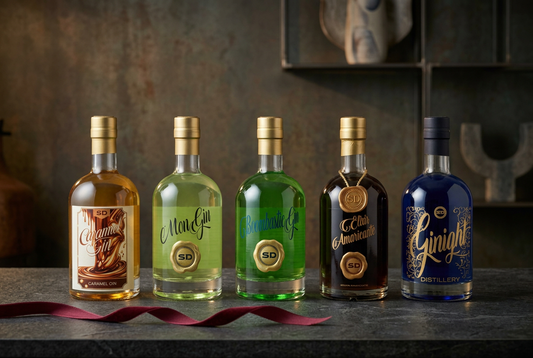 La gamma SD Distillery su un piano scuro con un nastro bordeaux, per la guida ai distillati da regalare.